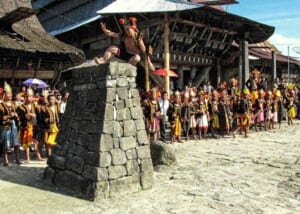 Photo of a Sumatran warrior hurdling atop a stone pedestal